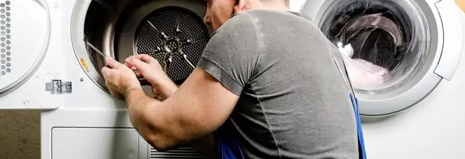 Dryer repair technician fixing a clothes dryer drum in Boulder, CO