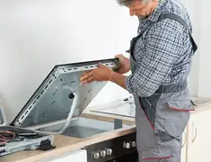 Appliance repair technician installing a built-in cooktop in Boulder, CO