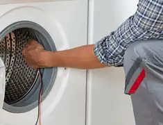 Dryer repair technician diagnosing and servicing a clothes dryer in Boulder, CO