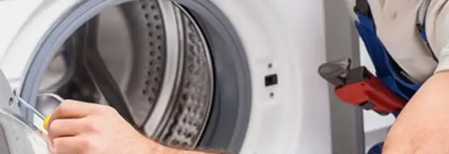 Appliance technician repairing a clothes dryer drum and internal parts in Boulder, CO