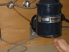 Garbage disposal repair technician tightening the mounting ring under a sink in Boulder, CO