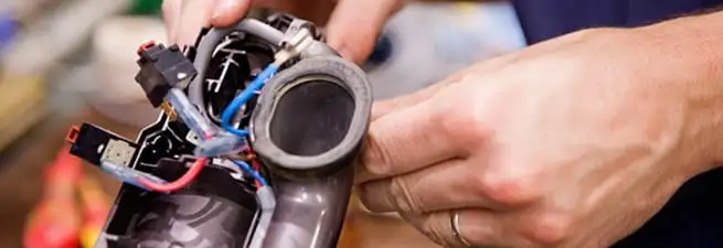 Vacuum repair technician reconnecting wiring and components in Boulder, CO
