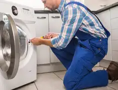 Washing machine repair technician servicing a front-load washer in Boulder, CO