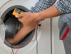 Washing machine repair technician testing a front-load washer with diagnostic tools in Boulder, CO