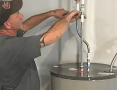 Water heater repair technician tightening supply line connections in Boulder, CO